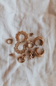 gold heart shaped earrings on white textile